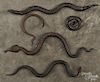 Four iron snakes, together with a coiled bronze example, longest - 16''.