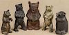 Four cast iron bear penny banks, together with a brass example, tallest - 6 1/2''.