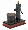 Cast iron Pump and Bucket mechanical bank, inscribed on base Compliments of Gusky's.