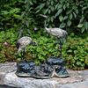 A bronze polychromed sculptural group of two red-crowned cranes, one with head lifted, the other with head down, on rockwork