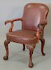 Chippendale style leather upholstered open arm chair with eagle head hand rests.