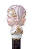 143. Porcelain Dress Cane- Ca. 1880- A hand painted porcelain handle with a woman frowning and on the other side she is smili