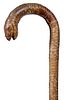 234. Snakeskin Hiking Cane - Ca. 1930 – A completely covered wood shaft with an exotic snakeskin and an open mouth, the hea
