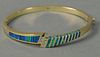 14K gold bangle style bracelet inlaid with green and blue and seven small diamonds (one small diamond missing). 24.5 grams.