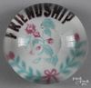 Colored frit Friendship paperweight, with a floral sprig over an opaque white ground, with top fac