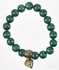 Russel Simmons malachite beaded stretch bracelet with a cage pendant, containing a rough cut diamond