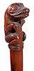 308. Ethnic Folk-Art Cane – Ca. 1910 – A carved one-piece mahogany shaft with a frog creature atop, the top left hand of