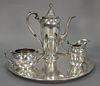 Sterling silver four piece tea set to include a round tray (dia. 12in.), creamer, sugar, and teapot (ht. 8 1/2in.), monogramm