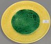 Large Wedgwood Majolica glazed plate having yellow leaf pattern and putty border around green glazed center having lioness wi