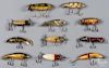 Eleven Heddon wood fishing lures, to include three SOS, three game fishers, two crab wigglers, and t