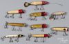 Nine Heddon wood fishing lures, to include three Torpedo's, two flaptails, and four Lucky 13, longes