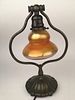 Tiffany Studios hape shaped base with a bell shaped shade.<BR>The base is stamped