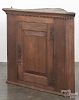 Pennsylvania pine hanging corner cupboard, late 18th c., with a dentil molded cornice and raised pan