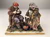 Antique capodimonte figurine of an old couple sitting.<BR>
