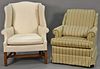 Two upholstered living room chairs including a white wing chair and a striped upholstered chair.