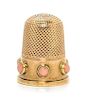 * An English Yellow Gold and Coral Thimble, , the knurled top and body above a plain band inset with six coral cabochons.