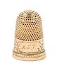 * A Yellow Gold Thimble, Possibly American, the knurled top and body above an engraved floral and foliate band bearing an eng