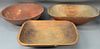 Three piece lot to include a large red painted and turned wood bowl and two troughs.  bowl: dia. 21 1/4in.  troughs: lg. 22in