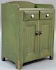 Primitive diminutive cabinet with gallery back and two drawers over two doors in green paint, set on cut out bracket base.  h