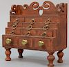 Miniature Federal chest having open work carved gallery over twelve drawers all set on turned legs in red paint (gallery repa