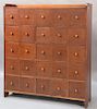 Spice cabinet having gallery top with twenty-five drawers set on boot jack ends.  ht. 50in., wd. 45in., dp. 12 1/2in. Provena