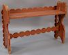 Red painted bucket bench having scallop carved back and support, on shelf on boot jack ends.  ht. 31in., wd. 45in., dp. 11 3/