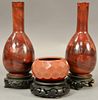 Three red agate pieces to include a pair of pear shaped vases with slender elongated necks (one broke and repaired) and a sma