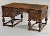 Jacobean-style Oak Writing Desk, late 19th/early 20th century, with a leather-inset top and foliate carved drawer fronts on f