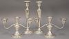 Four piece lot to include a pair of sterling silver weighted candelabra (lg. 9 3/4in.) and candlesticks (ht. 10in.).