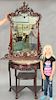 Oriental demilune table with mirror, having inset marble top over carved skirt and three curio shelves. ht. 31in., wd. 33in.,
