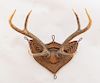 PAIR OF THREE-POINT STAG ANTLERS, MOUNTED ON INDIAN CANE SHIELD-SHAPED BACK