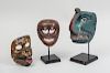 THREE SOUTHEAST ASIA PAINTED MASKS, TWO ON STANDS