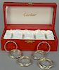 Four Cartier Trinity sterling silver napkin rings in fitted case.