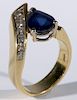 18 karat gold ladies ring set with teardrop blue sapphire and five diamonds. size 6 1/2