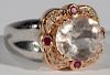 Ladies 14 karat two tone ring continuing one oval 12x10mm morganite with light tone, the setting contains four 2mm round rubi