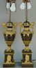 Pair of bronze and gilt bronze urns made into table lamps, set on square bases with classical gilt figures. urn ht. 19 3/4in.