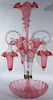 Victorian cranberry art glass epergne having ribbon edge bowl fitted with four ribbon edge vases and three clear glass canes