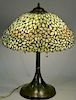 Leaded table lamp with yellow flowers on metal bronze patinated base, shade decorated with flowers and leaves, attributed to