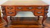Mahogany partners desk having female leg supports on cabriole legs ending in large paw feet and carved pulls having glass top
