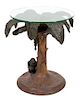 A Palm Tree-Form Composite and Glass Top Table Height 29 inches, diameter of base 27 inches.