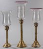 Three brass candlesticks, mid 19th c., with etched hurricane shades, tallest - 23''.