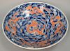 Large Chinese porcelain four claw dragon dish/charger having iron red dragons amongst blue and white clouds. dia. 21in.
