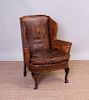 GEORGE III STYLE MAHOGANY AND LEATHER UPHOLSTERED WING CHAIR
