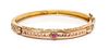 A 14 Karat Bicolor Gold and Ruby Simulant Bangle Bracelet, 12.10 dwts.