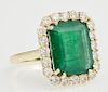 Lady's 18K Yellow Gold Dinner Ring, with an 8.22 carat emerald atop a border of round diamonds, total diamond weight- 1.5 cts