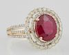 Lady's 14K Yellow Gold Dinner Ring, with an oval 3.96 carat ruby atop a border of small round diamonds and a pierced concentr