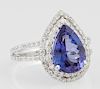 Lady's Platinum Dinner Ring, with a 4.84 carat pear shaped tanzanite atop two pierced concentric graduated borders of small r