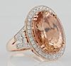 Lady's 14K Rose Gold Dinner Ring, with a 10.91 carat oval morganite, atop a border of round diamonds, the split sides of the 