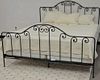 King size iron bed, complete with frame, mattress, box springs, bedspread, three shams, and skirt. ht. 54 in.