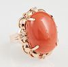 Lady's 14K Rose Gold Dinner Ring, with a 20.93 carat oval cabochon coral atop a curved pierced border mounted with six white